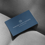 Blue business card with white text and logo on a textured gray surface