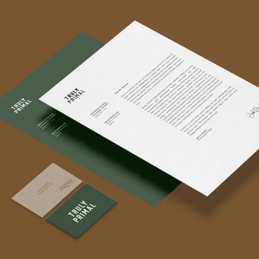 Truly Primal branding materials including a letterhead, business card, and menu on a brown background.